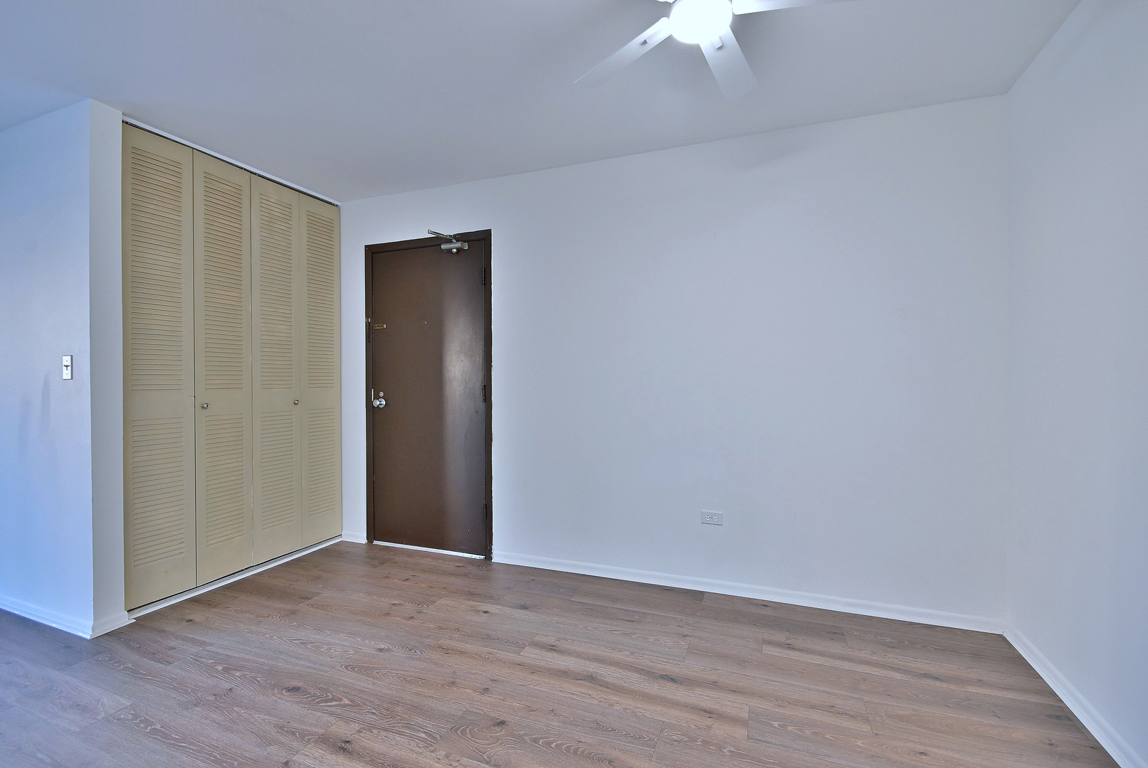 6177 Knoll Wood Road, Unit 102 Willowbrook, IL 60527 - Photo 3 of 19 a view of an empty room with wooden floor a ceiling fan and window