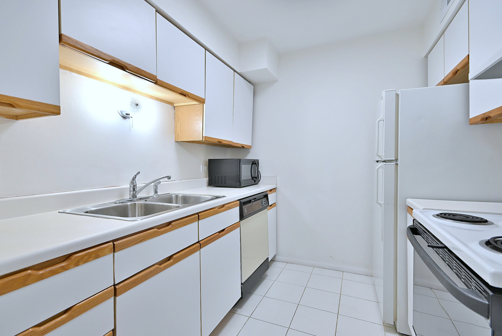6177 Knoll Wood Road, Unit 102 Willowbrook, IL 60527 - Photo 5 of 19 a kitchen with a sink and a refrigerator