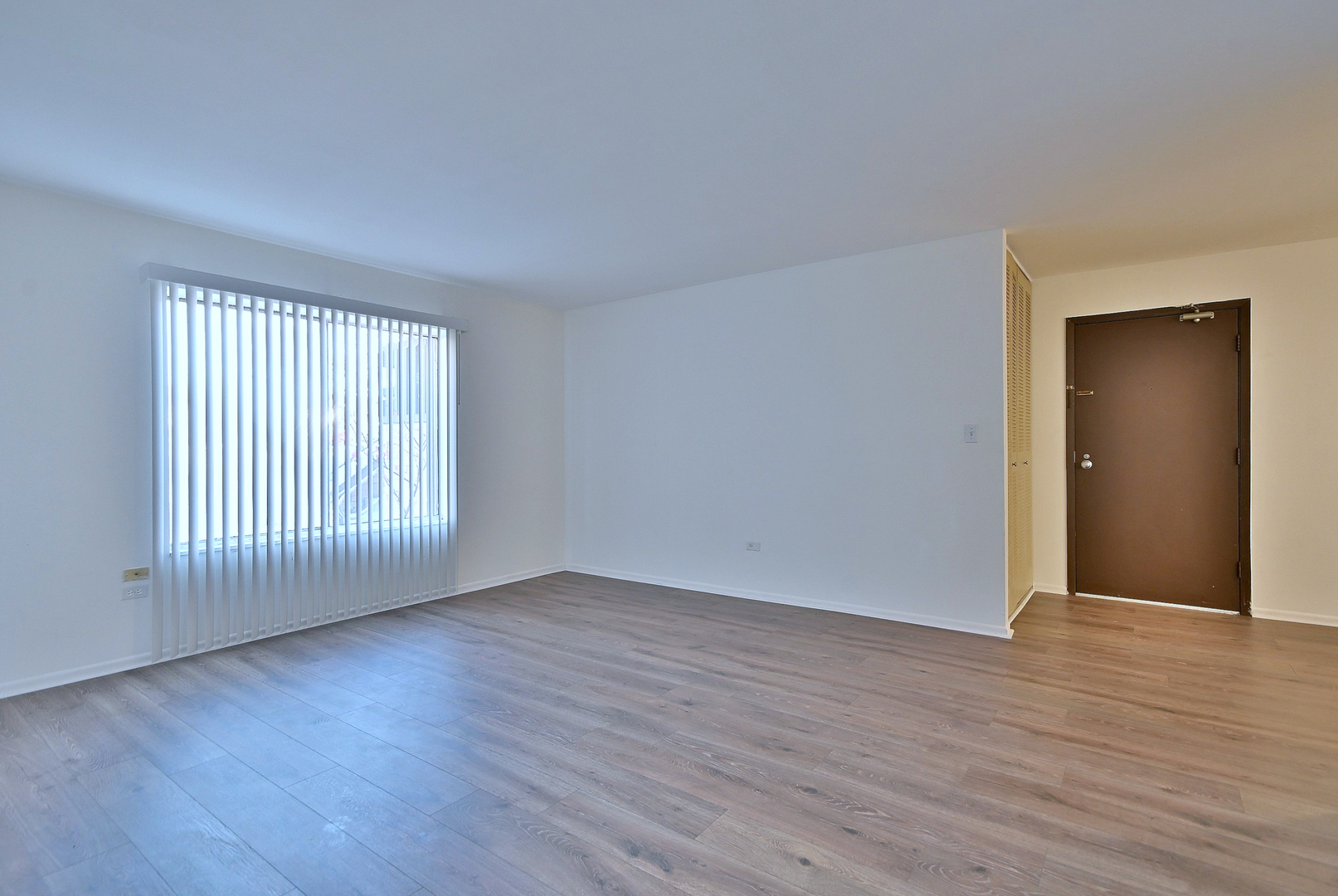 6177 Knoll Wood Road, Unit 102 Willowbrook, IL 60527 - Photo 8 of 19 a view of an empty room with wooden floor and a window