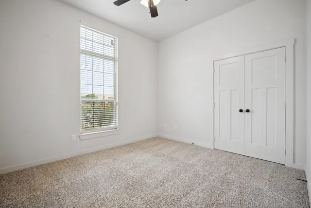 an empty room with windows and closet
