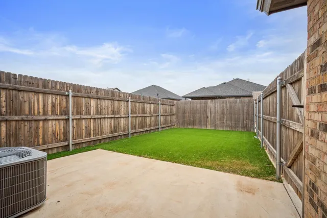 a view of a backyard with wooden fence