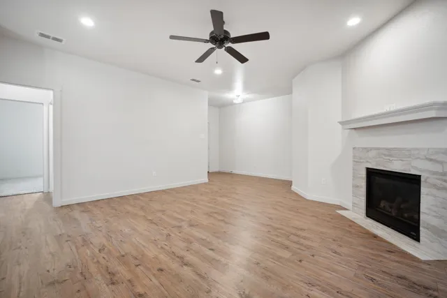 a view of empty room with wooden floor and fireplace