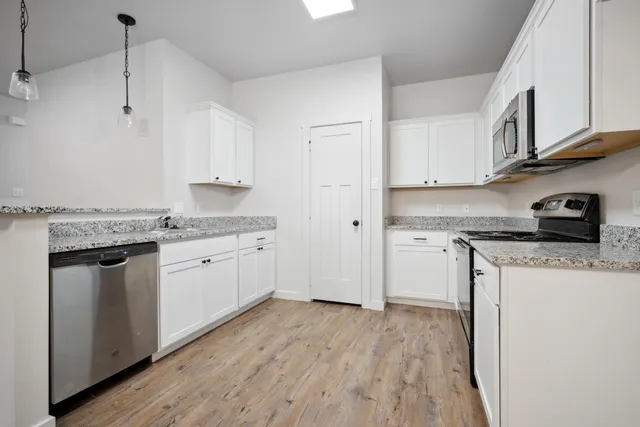 a kitchen with granite countertop white cabinets and white appliances