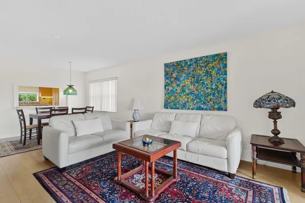 a living room with furniture a rug a lamp and a window