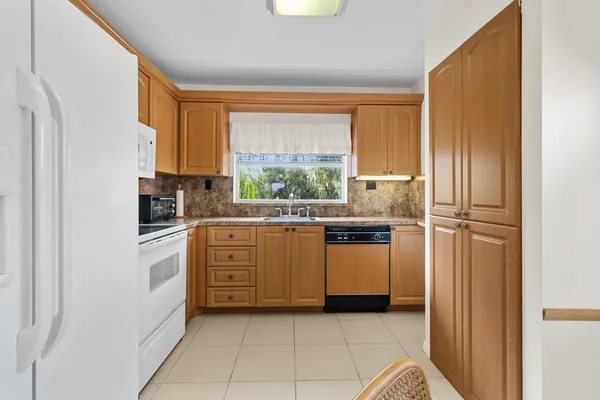 a kitchen with white cabinets and white appliances