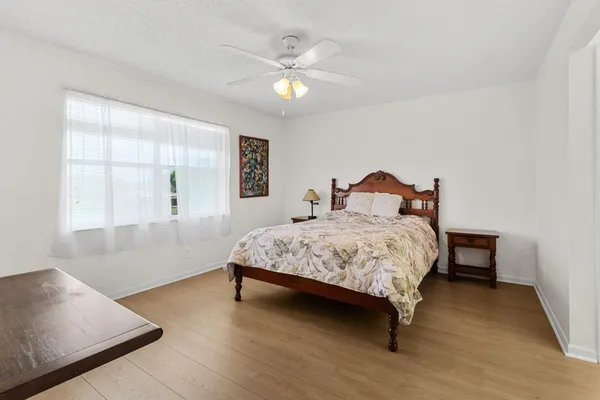 a bedroom with a large bed and a ceiling fan
