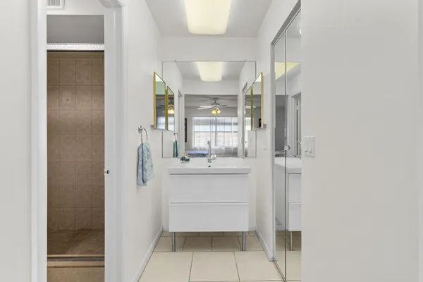 a bathroom with a sink mirror and shower