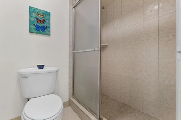 a white toilet sitting next to a shower