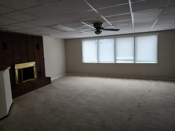 a view of an empty room with a fireplace and a window
