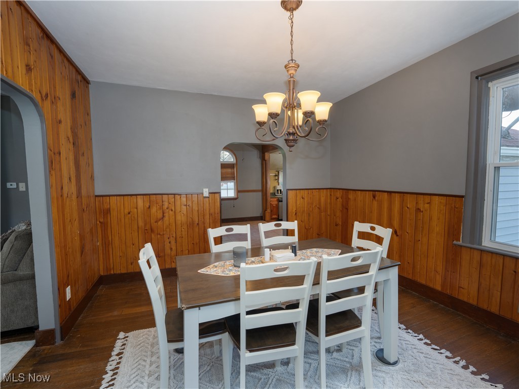 2399 Columbiana Road New Springfield, OH 44443 - Photo 2 of 38 Dining area with wood walls, arched walkways, dark wood-type flooring, wainscoting, and a chandelier