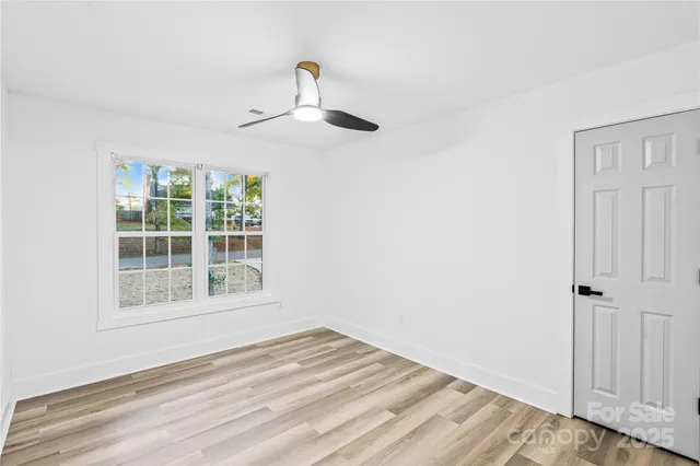 a view of empty room with wooden floor