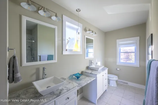 a bathroom with a granite countertop sink a mirror and a bathtub