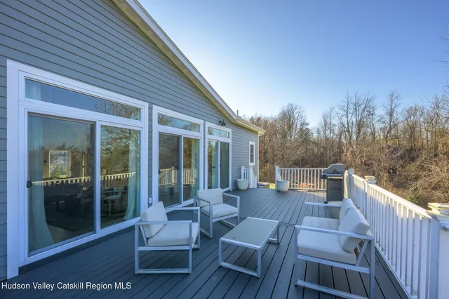 a view of a patio with couches chairs and wooden floor