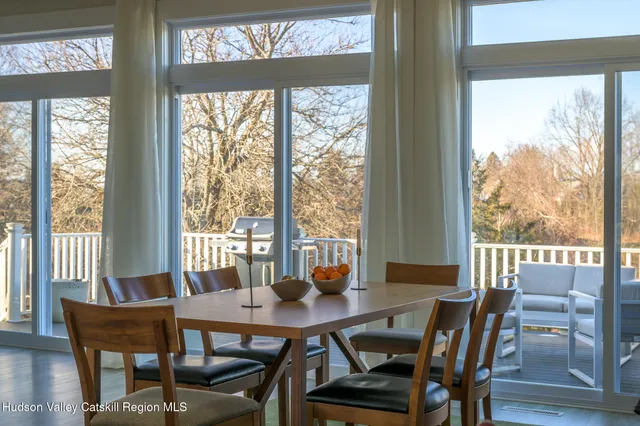 a view of a dining room with furniture large windows and wooden floor