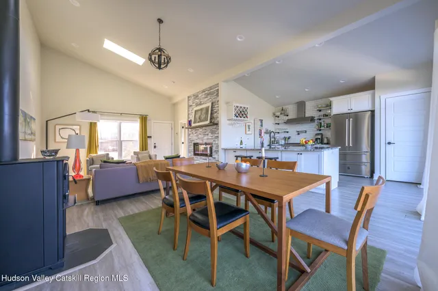 a dining room with furniture a kitchen and chandelier