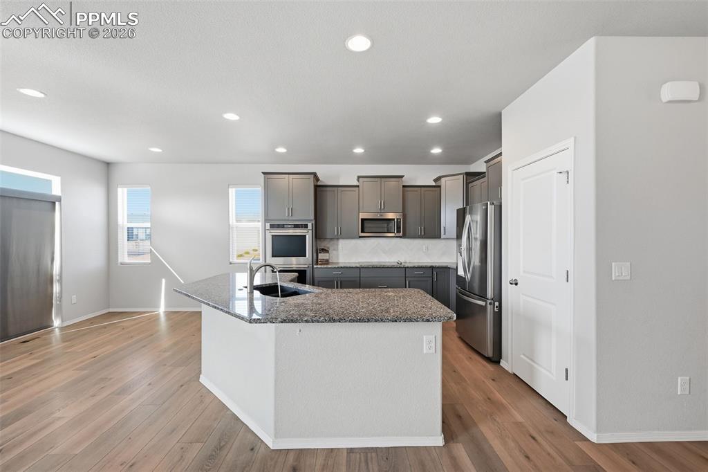 9962 Hidden Ranch Court Peyton, CO 80831 - Photo 11 of 48 a kitchen with stainless steel appliances granite countertop a sink stove and refrigerator