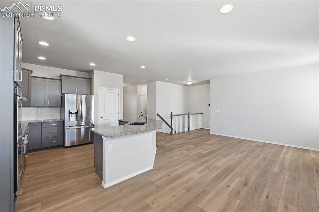 9962 Hidden Ranch Court Peyton, CO 80831 - Photo 12 of 48 a large kitchen with stainless steel appliances kitchen island a large counter top and a wooden floors