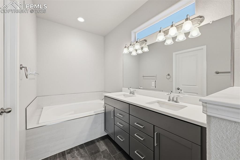 9962 Hidden Ranch Court Peyton, CO 80831 - Photo 20 of 48 a bathroom with a tub a sink and mirror