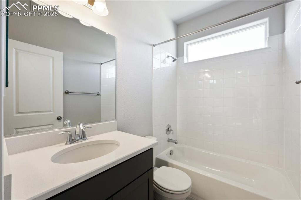 9962 Hidden Ranch Court Peyton, CO 80831 - Photo 28 of 48 a bathroom with a granite countertop sink toilet a mirror and a bathtub