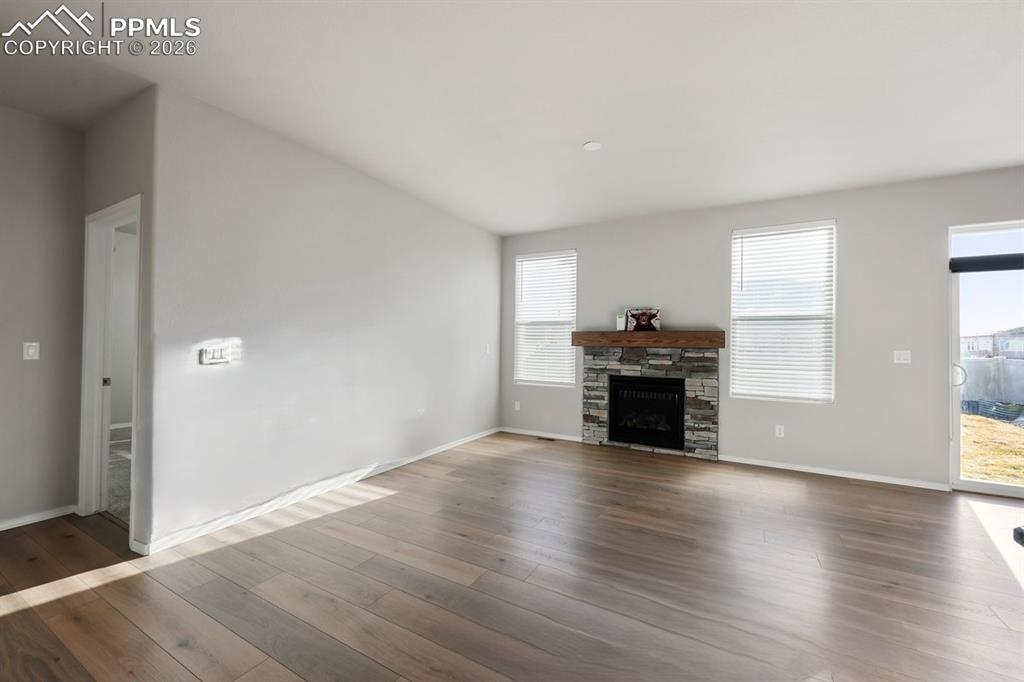 9962 Hidden Ranch Court Peyton, CO 80831 - Photo 4 of 48 an empty room with wooden floor fireplace and windows