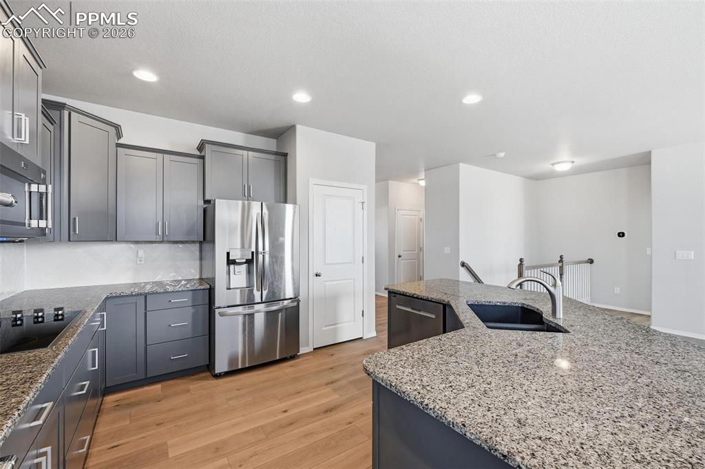 9962 Hidden Ranch Court Peyton, CO 80831 - Photo 8 of 48 a kitchen with stainless steel appliances granite countertop a sink refrigerator and cabinets