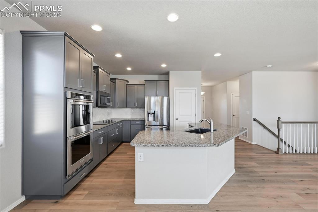 9962 Hidden Ranch Court Peyton, CO 80831 - Photo 10 of 48 a kitchen with kitchen island stainless steel appliances granite countertop a sink a refrigerator and a stove
