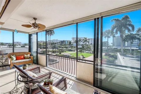 a balcony with furniture and a floor to ceiling window