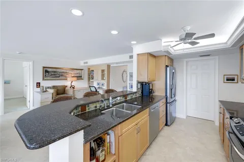 a kitchen with stainless steel appliances granite countertop a sink a stove and refrigerator