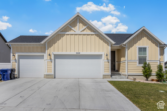 2994 Tangent Peak Road Magna, UT 84044 - Photo 1 of 1 View of front of property featuring board and batten siding, an attached garage, concrete driveway, and a front lawn