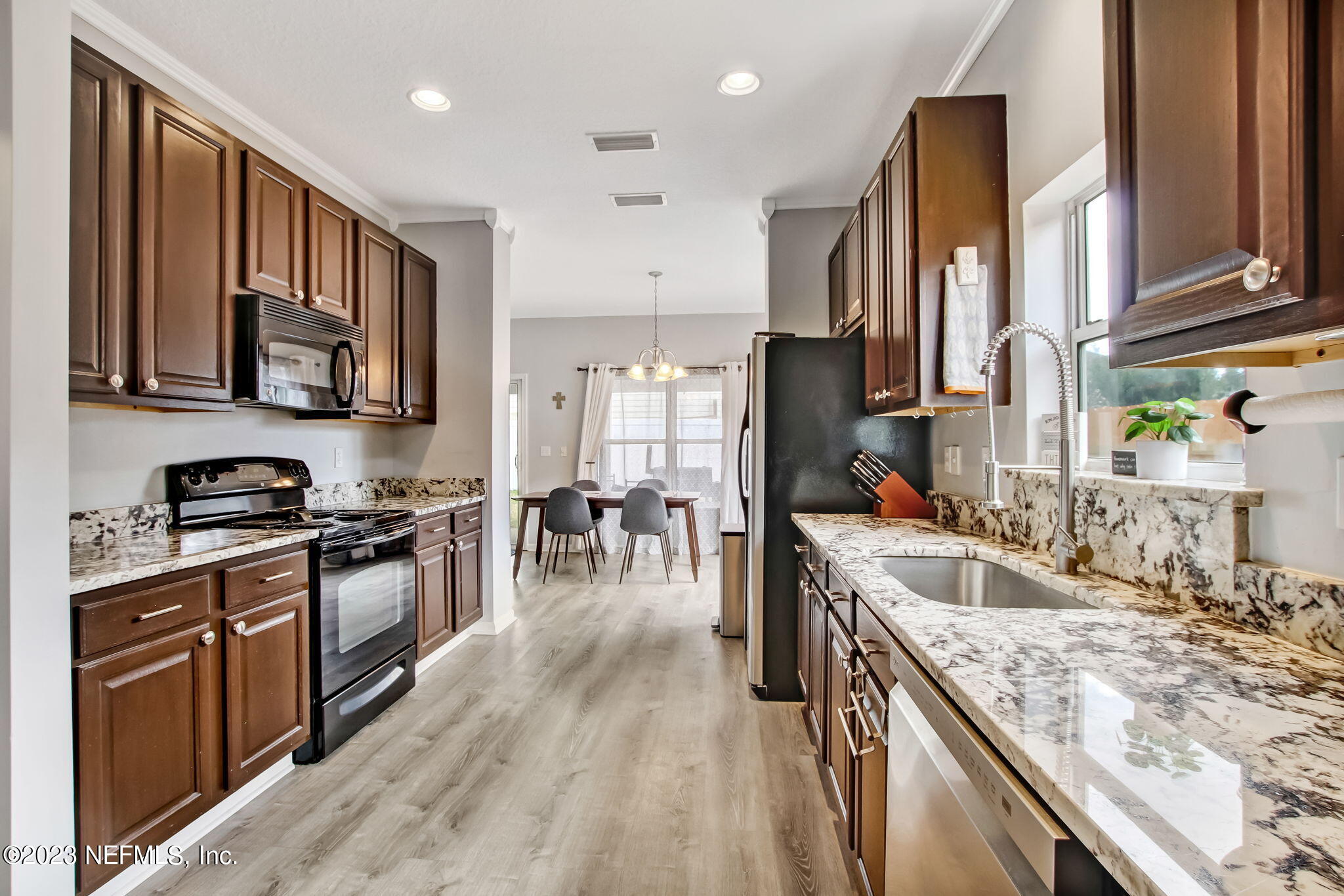 96054 Ridgewood Circle Fernandina Beach, FL 32034 - Photo 11 of 32 a kitchen with stainless steel appliances granite countertop sink stove top oven and cabinets