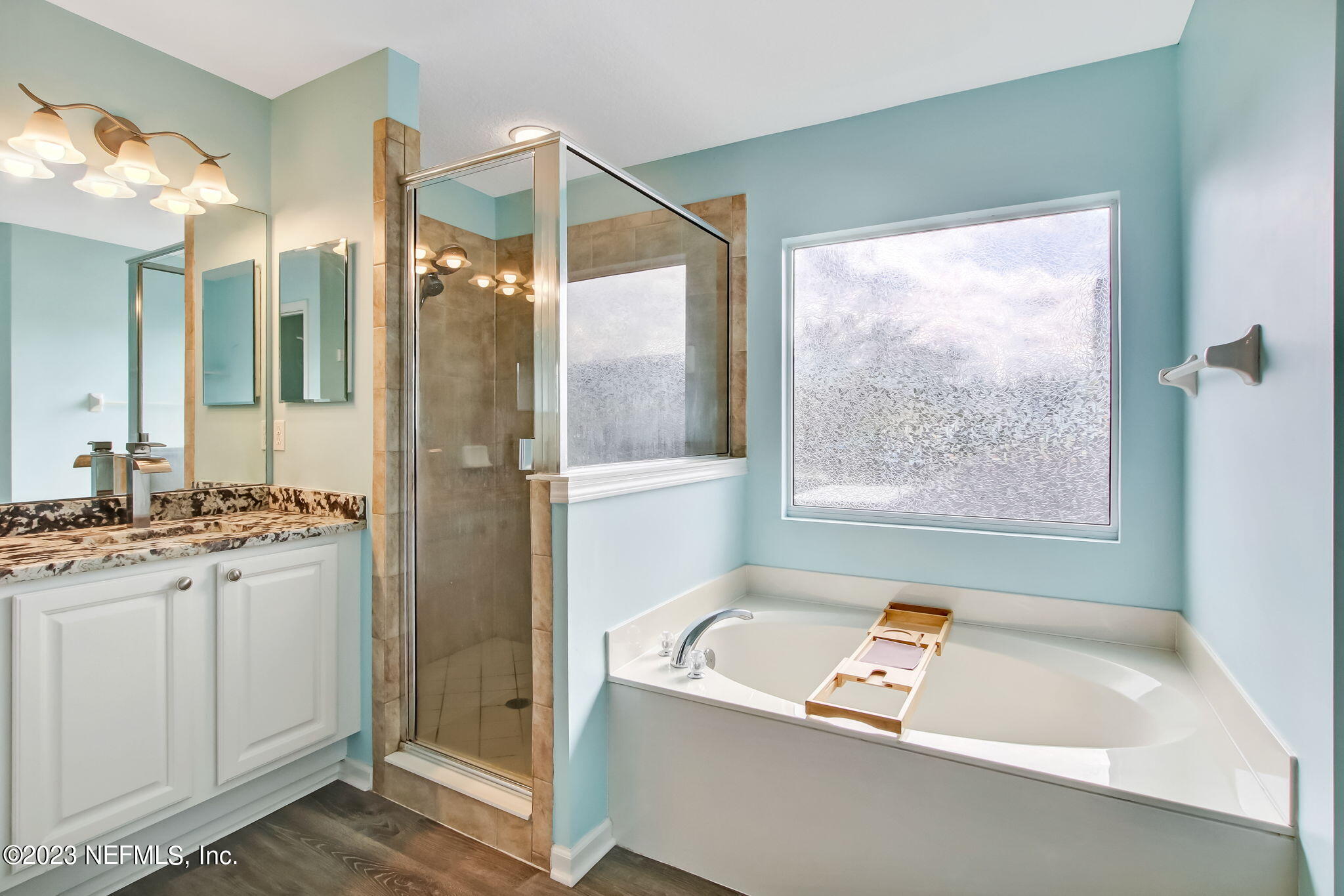 96054 Ridgewood Circle Fernandina Beach, FL 32034 - Photo 18 of 32 a bathroom with a tub a sink and a large mirror