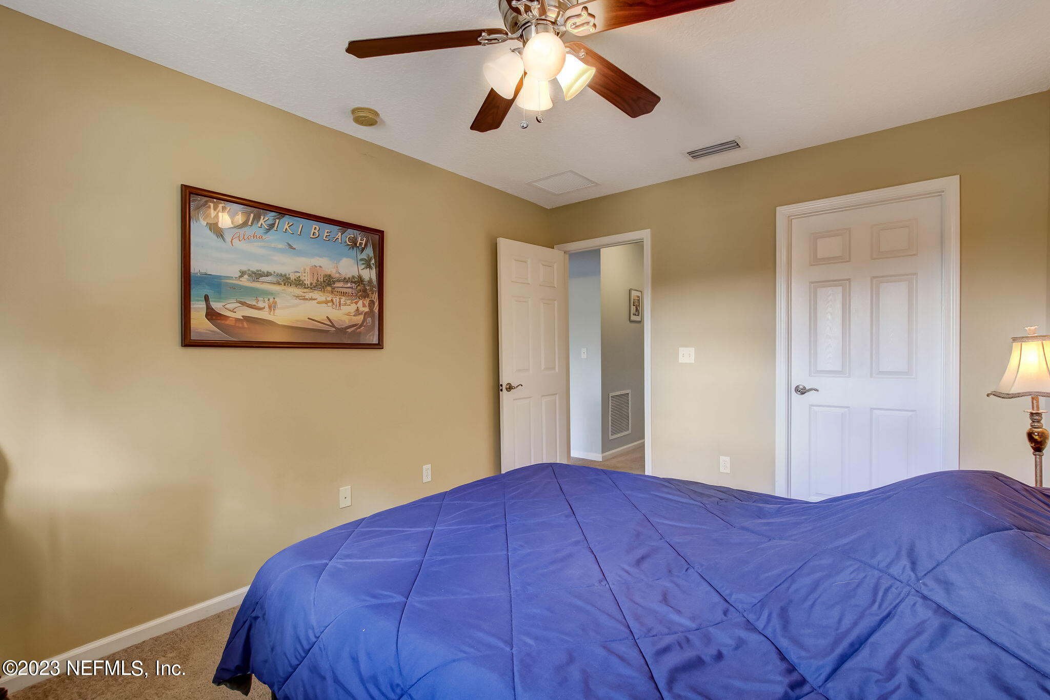 96054 Ridgewood Circle Fernandina Beach, FL 32034 - Photo 20 of 32 a bedroom with a bed and a chandelier
