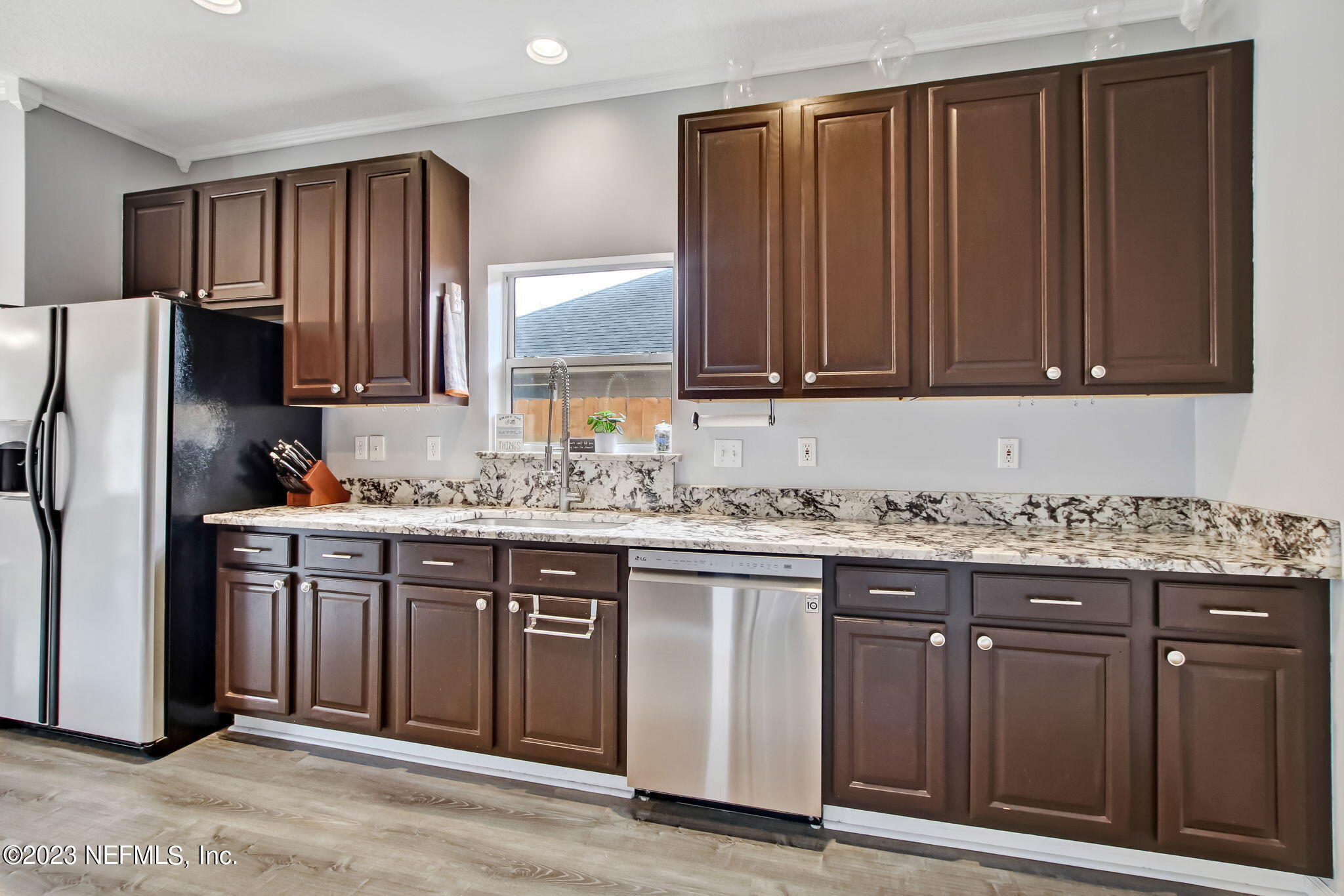 96054 Ridgewood Circle Fernandina Beach, FL 32034 - Photo 10 of 32 a kitchen with granite countertop wooden cabinets stainless steel appliances and a sink
