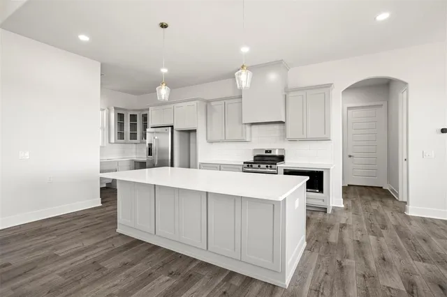a kitchen with kitchen island a sink stainless steel appliances and cabinets