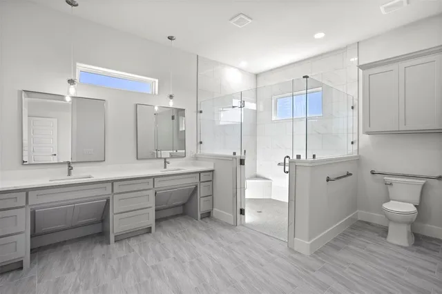 a large bathroom with a double vanity sink a toilet and a large mirror