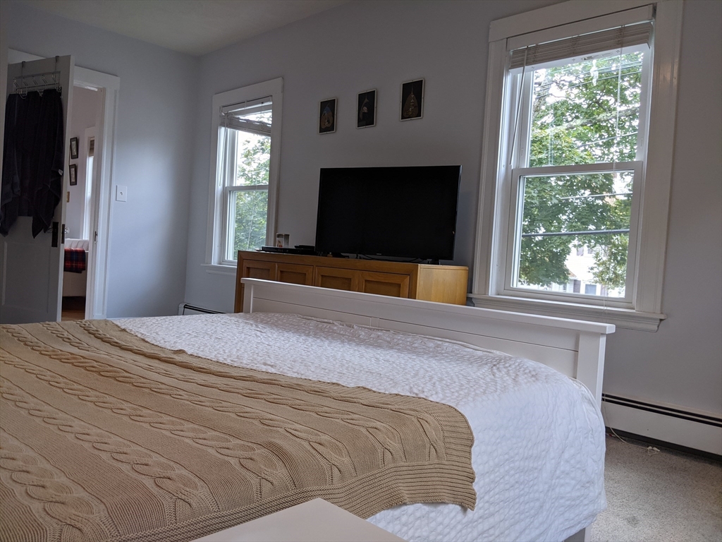 184 White Street, Unit 2 Belmont, MA 02478 - Photo 13 of 29 a bedroom with a bed and a flat screen tv