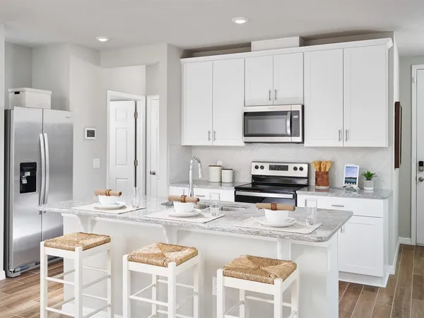 a kitchen with stainless steel appliances kitchen island granite countertop a stove a sink and a refrigerator