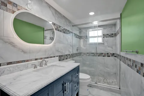a bathroom with a granite countertop sink a toilet and a mirror