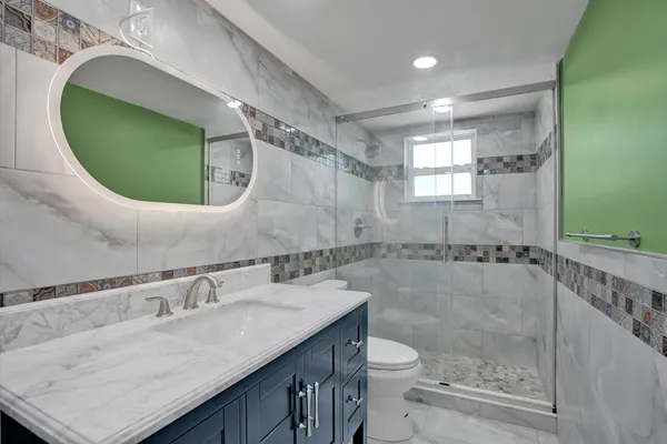a bathroom with a granite countertop sink a toilet and a mirror