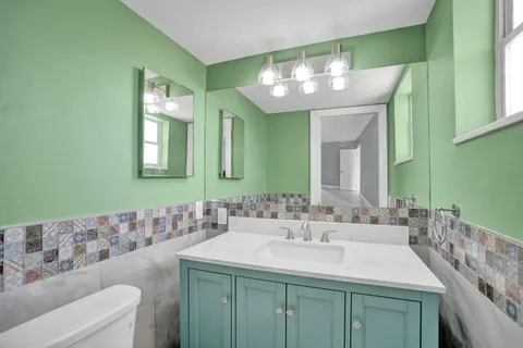 a bathroom with a toilet sink and mirror