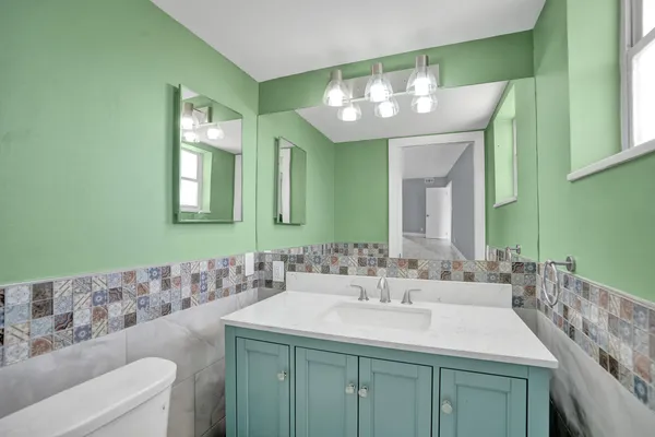 a bathroom with a toilet sink and mirror