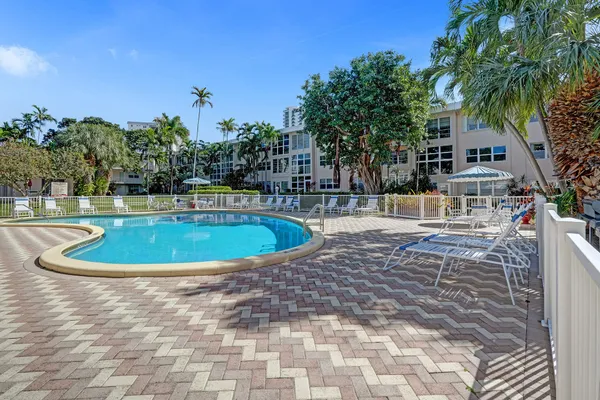 a view of a white house with a swimming pool and yard