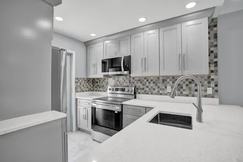 a kitchen with white cabinets and stainless steel appliances