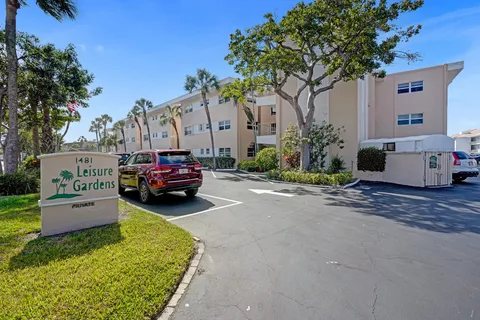 a row of palm trees in front of a building
