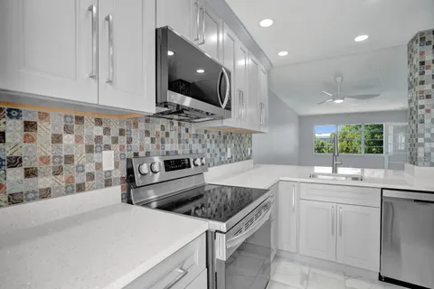a kitchen with stainless steel appliances a sink a stove a microwave a sink and cabinets
