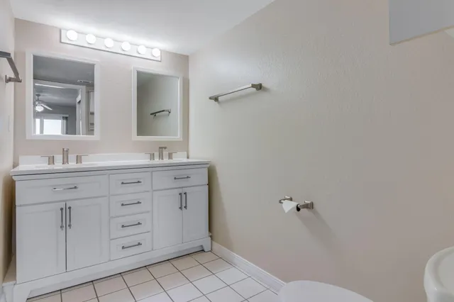 a bathroom with a granite countertop sink mirror vanity and toilet