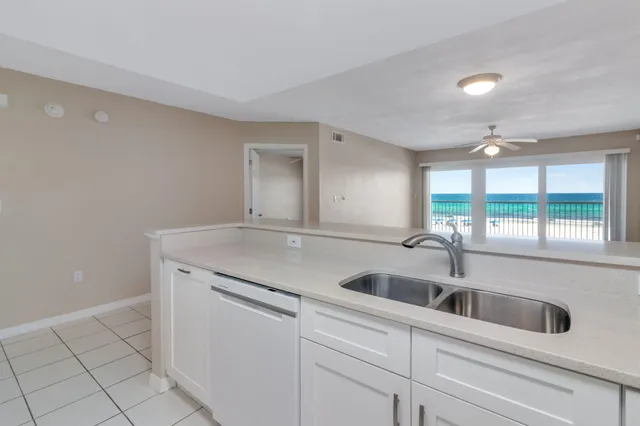 a kitchen with granite countertop a sink and white cabinets