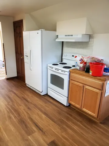 a kitchen with a stove top oven and refrigerator