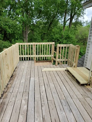 a view of balcony with wooden floor and fence