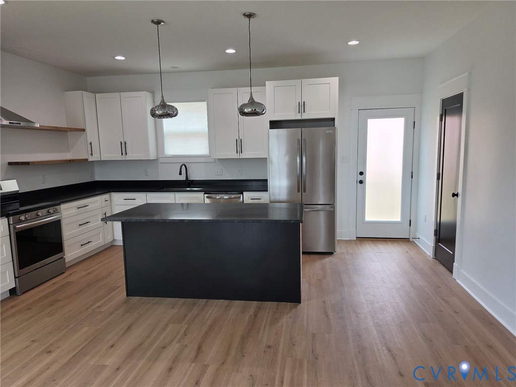 901 Commerce Street Petersburg, VA 23803 - Photo 15 of 40 a kitchen with stainless steel appliances granite countertop a stove a refrigerator and a microwave